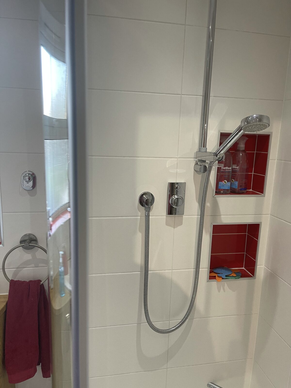 Photograph of a shower with a main control in the shower and a remote control beside the shower