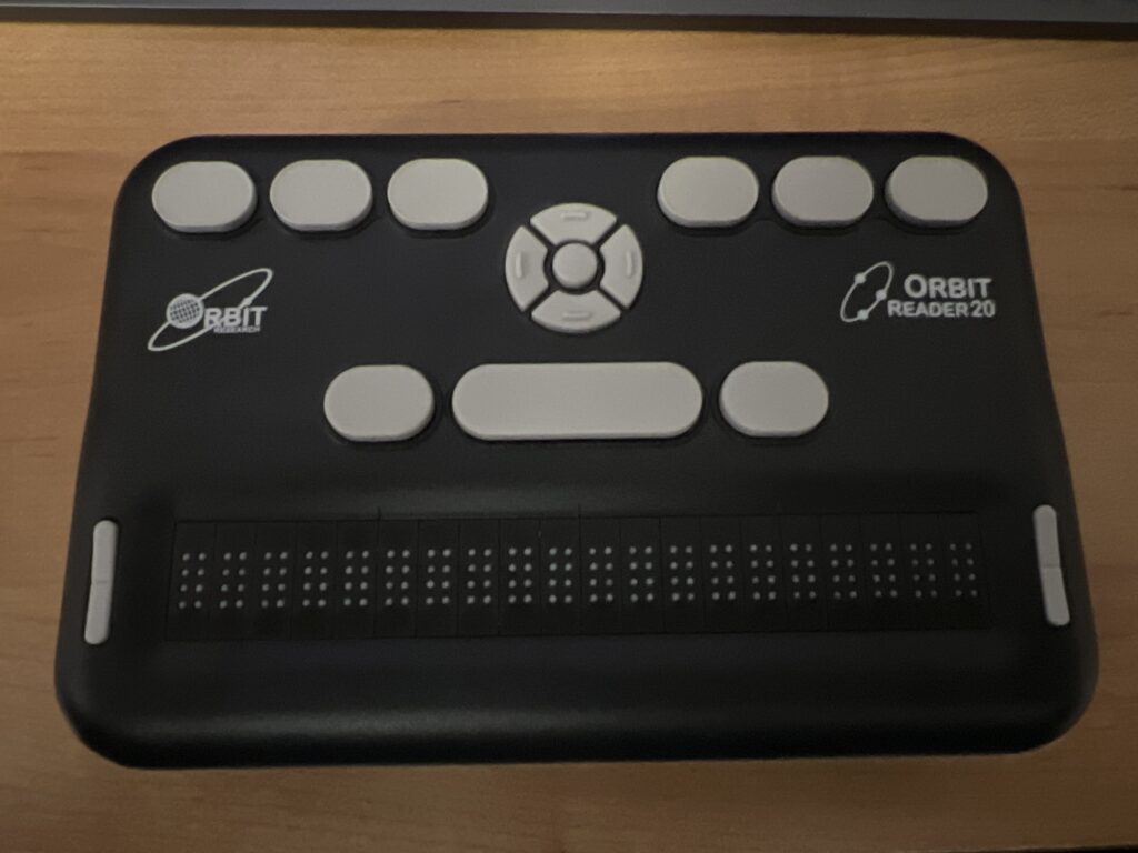 Photo of an Orbit Reader 20. A black rectangular device with perkin style keys. Below the keys are 20 cells of 8 dot braille.