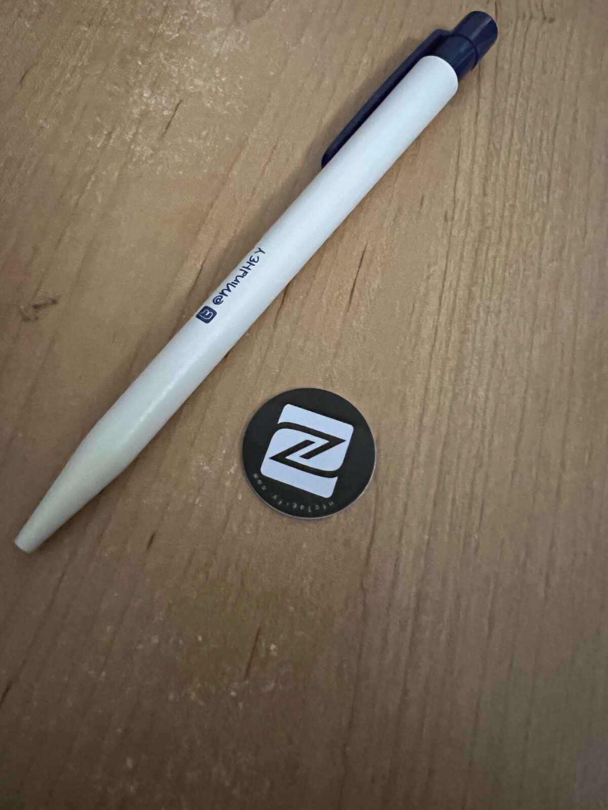A pen next to an NFC tag that can be used to trigger Apple Shortcuts