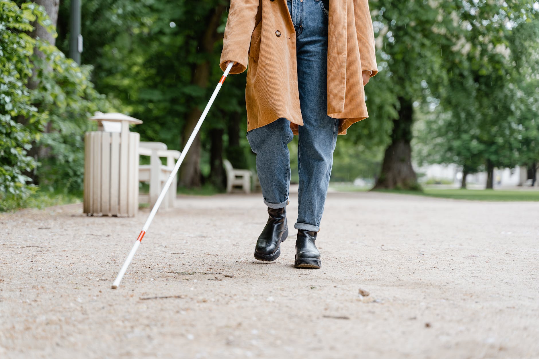 person in brown coat and blue denim jeans walking